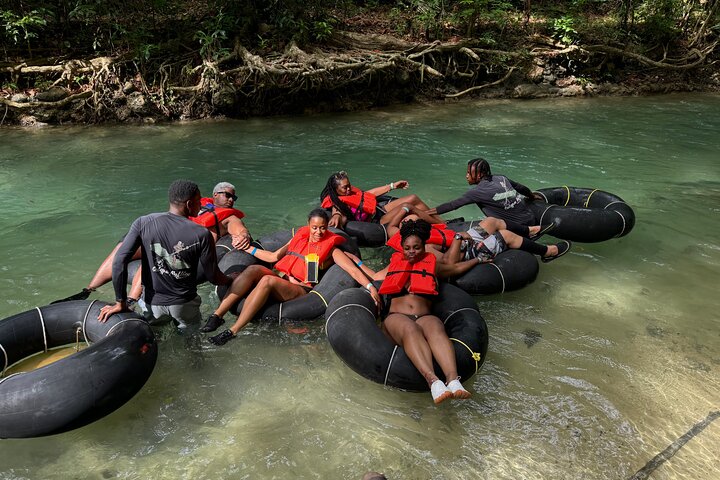 Visitors tubing down White River amidst vibrant jungle scenery