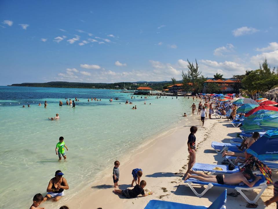 Cruise passengers relaxing at Blue Water Beach on a shore excursion from Falmouth cruise port in Jamaica